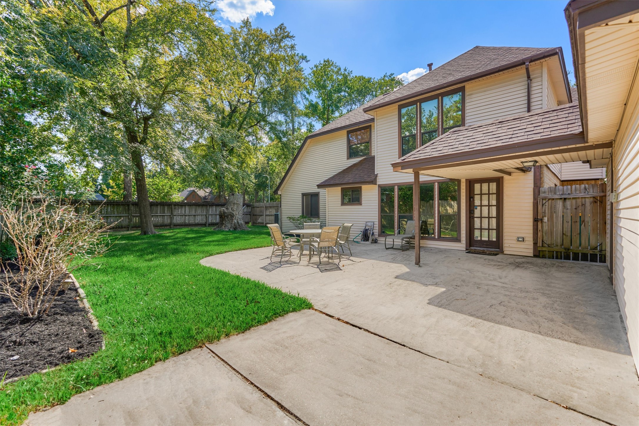25706 Overlake Drive Spring, TX 77380 - Photo 26 of 32 Spacious backyard patio perfect for outdoor dining and relaxation, surrounded by lush greenery for added privacy.