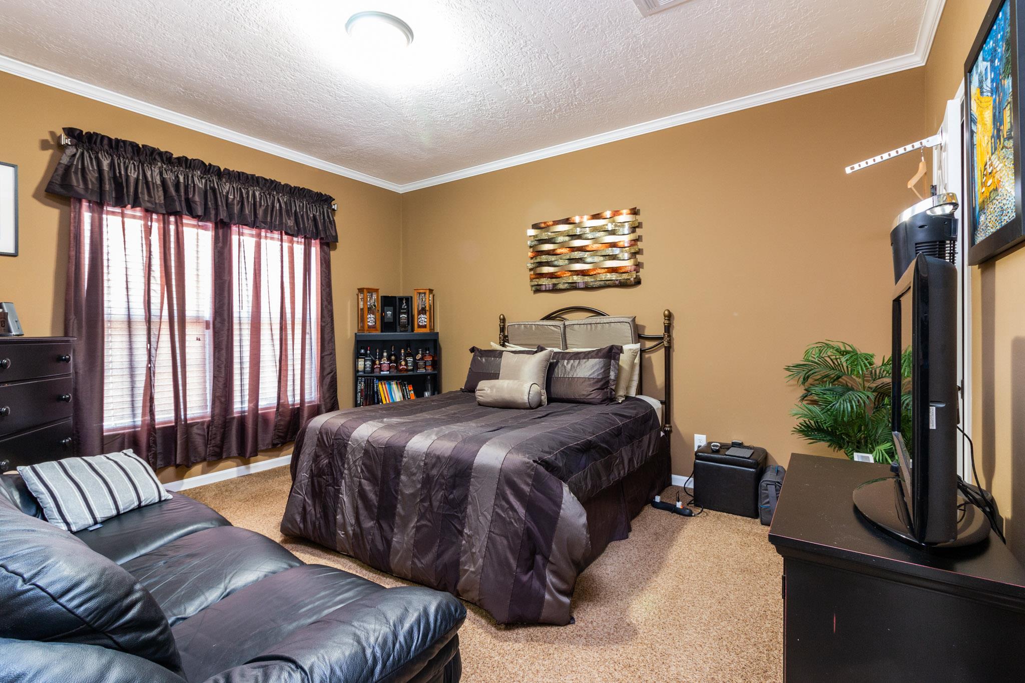 588 York Hollow Road Pulaski, TN 38478 - Photo 14 of 16 a bedroom with a large bed and a flat tv screen on dresser