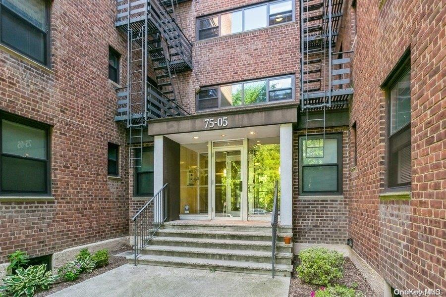 75-05 210th Street, Unit 2P Queens, NY 11364 - Photo 16 of 20 a view of a brick house with a large window and potted plants
