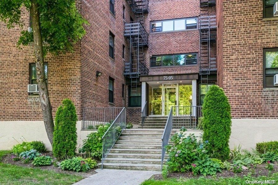 75-05 210th Street, Unit 2P Queens, NY 11364 - Photo 19 of 20 a front view of a brick building with a yard