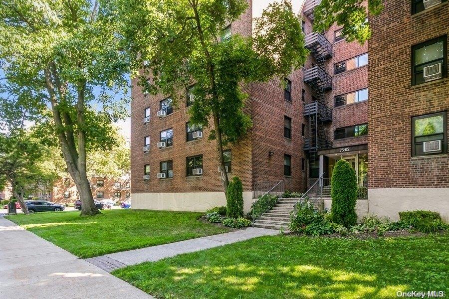75-05 210th Street, Unit 2P Queens, NY 11364 - Photo 3 of 20 front view of a brick house with a yard