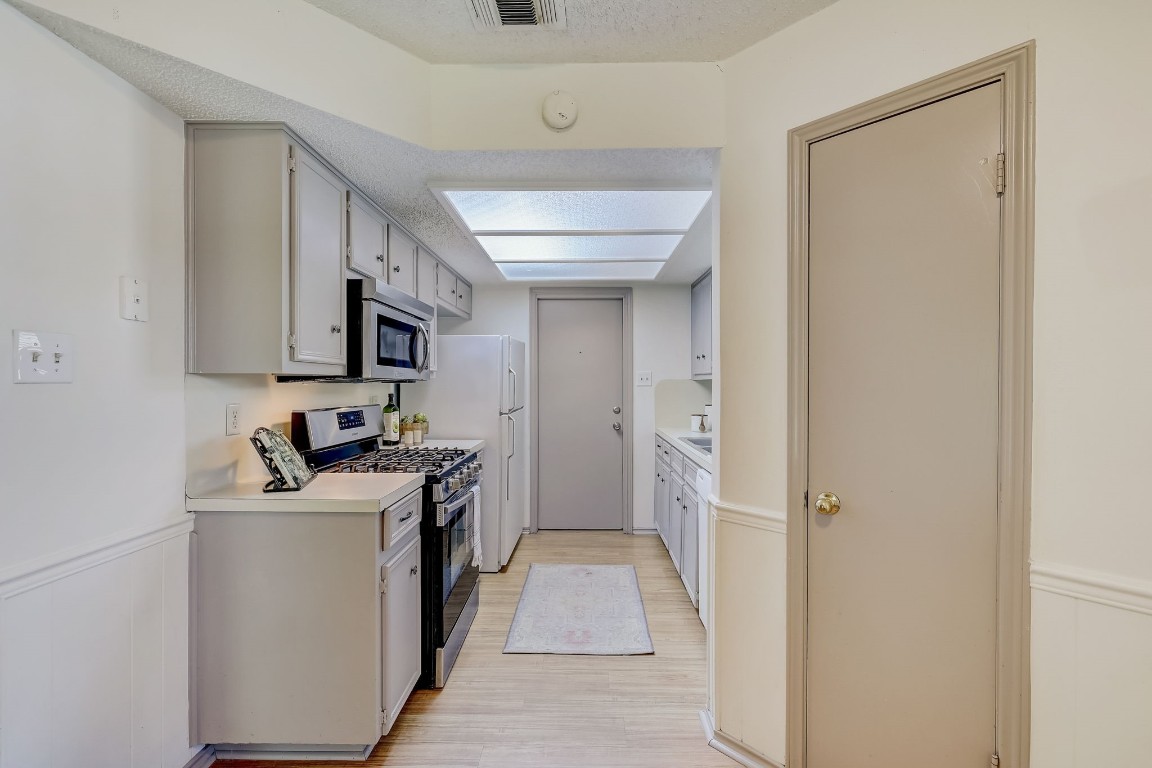 1709 Goodson Lane Round Rock, TX 78664 - Photo 12 of 37 a kitchen with a sink a stove top oven and white cabinets