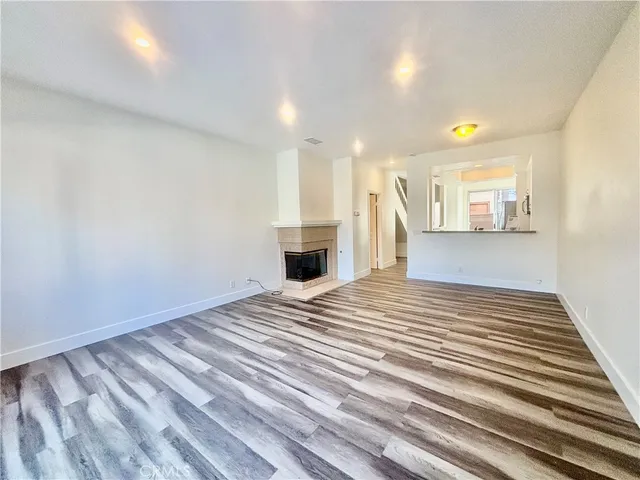 a view of a livingroom with wooden floor and a fireplace