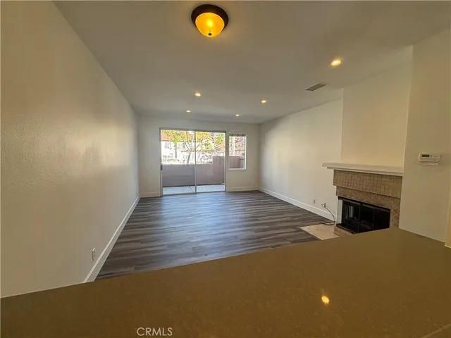 a view of empty room with window and wooden floor