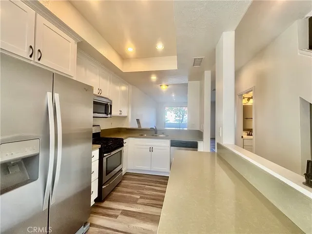 a modern kitchen with stainless steel appliances granite countertop a refrigerator and a sink