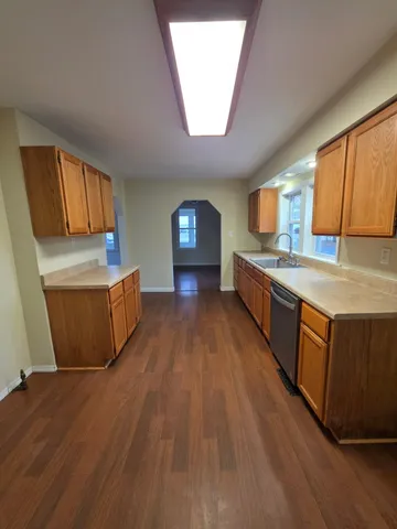 a large kitchen with wooden floors and stainless steel appliances