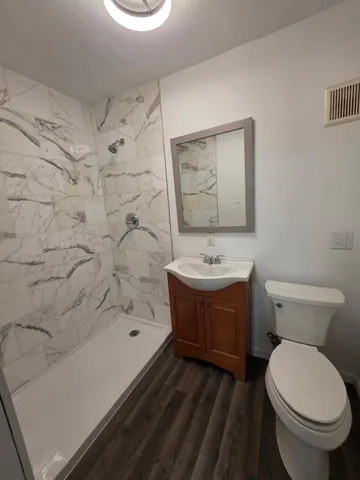 a bathroom with a sink a toilet and shower