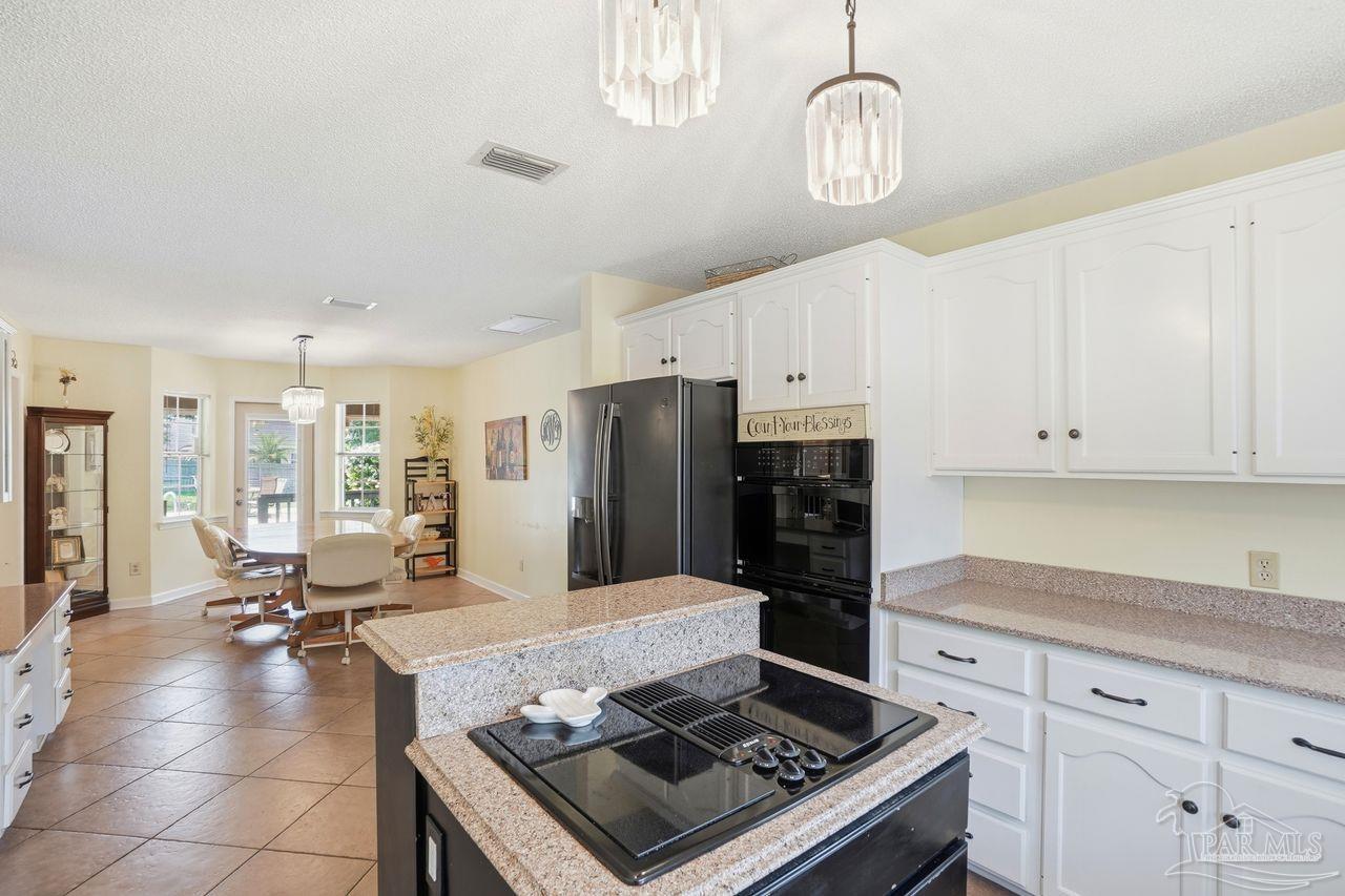 1437 Kings Road Cantonment, FL 32533 - Photo 14 of 67 a kitchen with a stove a refrigerator and cabinets