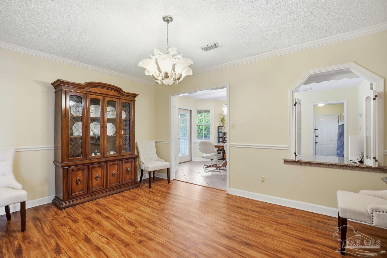 1437 Kings Road Cantonment, FL 32533 - Photo 19 of 67 a view of a livingroom with furniture wooden floor a chandelier