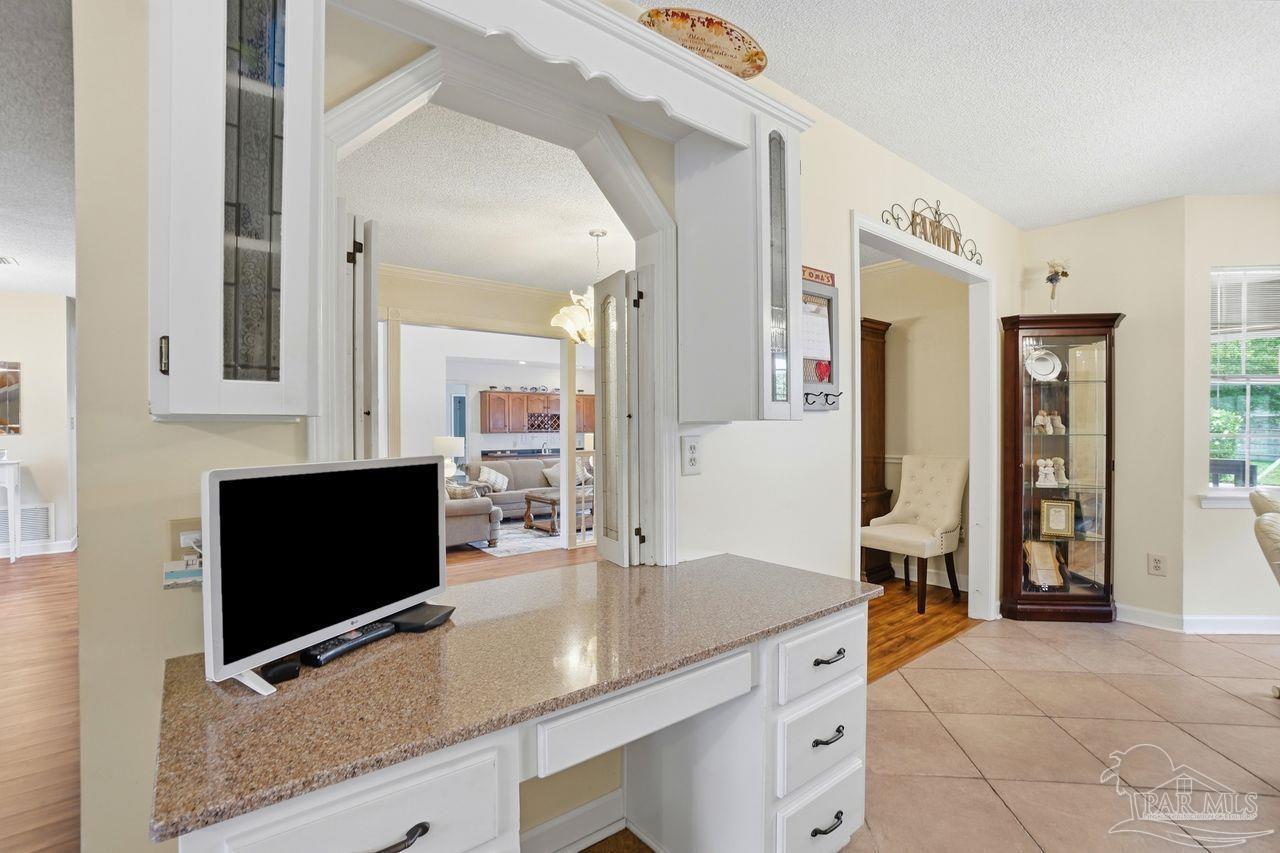 1437 Kings Road Cantonment, FL 32533 - Photo 20 of 67 a living room with stainless steel appliances kitchen island granite countertop a sink and a flat screen tv