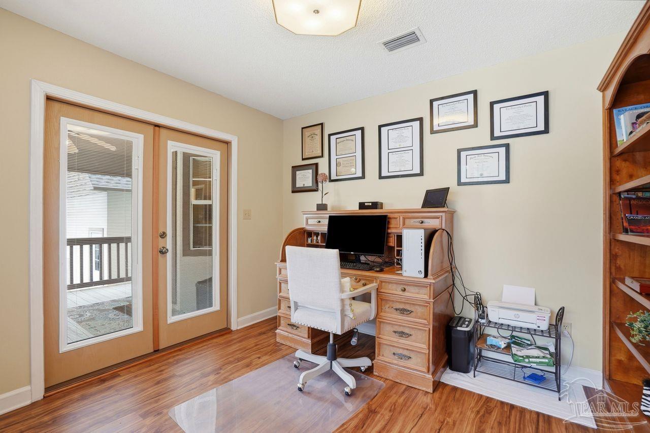 1437 Kings Road Cantonment, FL 32533 - Photo 22 of 67 a view of a workspace with wooden floor and white walls