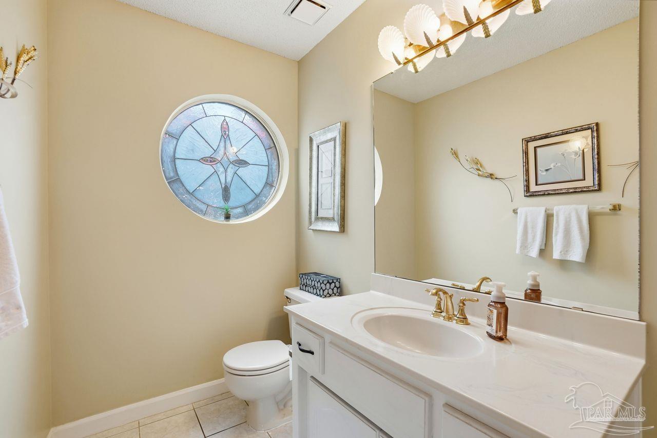 1437 Kings Road Cantonment, FL 32533 - Photo 37 of 67 a bathroom with a toilet a sink and mirror