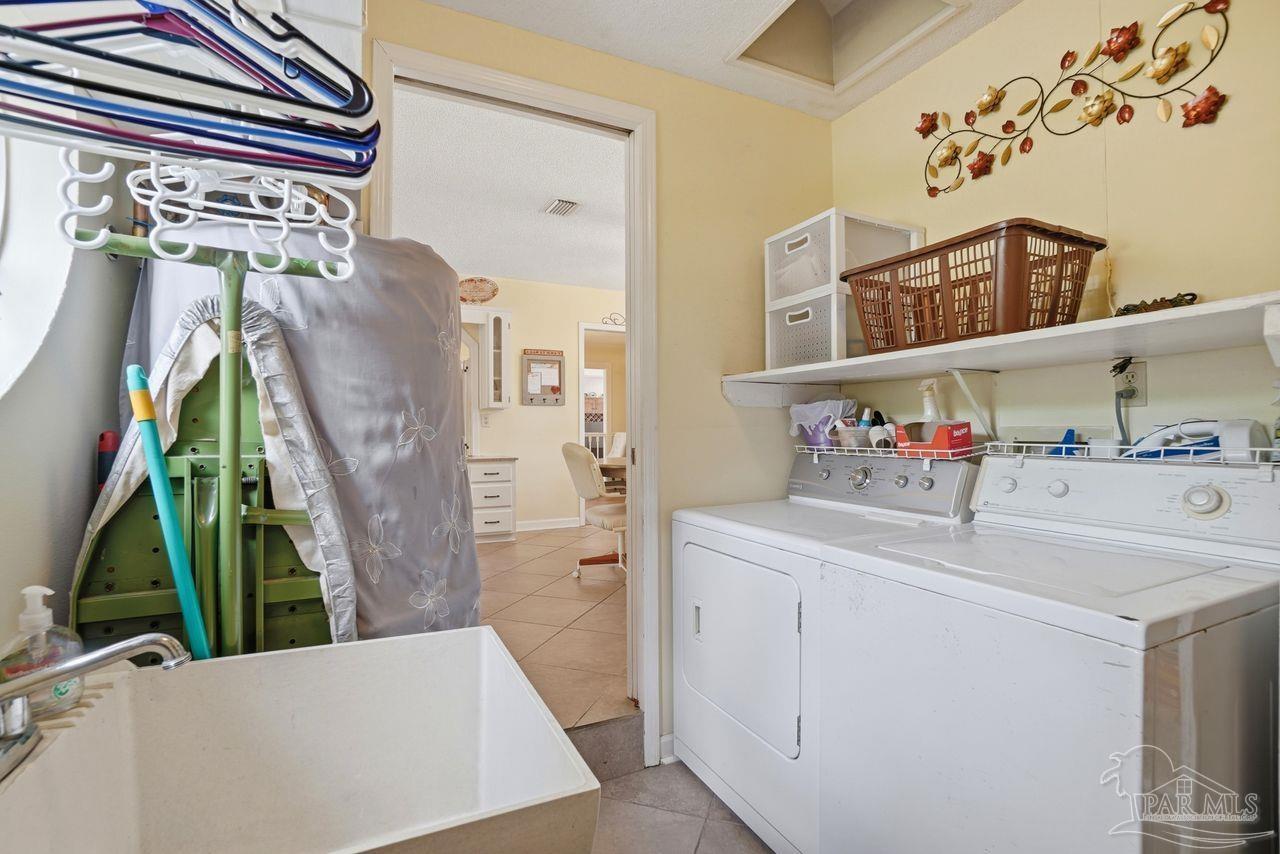 1437 Kings Road Cantonment, FL 32533 - Photo 49 of 67 a utility room with cabinets washer and dryer
