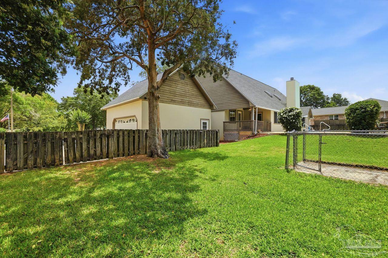 1437 Kings Road Cantonment, FL 32533 - Photo 57 of 67 a view of a house with a yard and a large tree