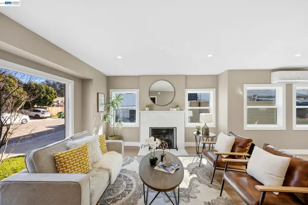 a living room with furniture fireplace and a large window