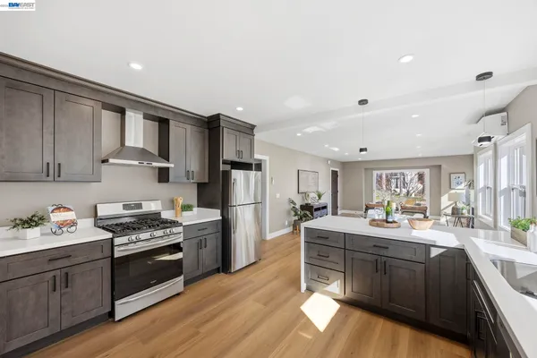 a kitchen with granite countertop stainless steel appliances a sink a stove and cabinets