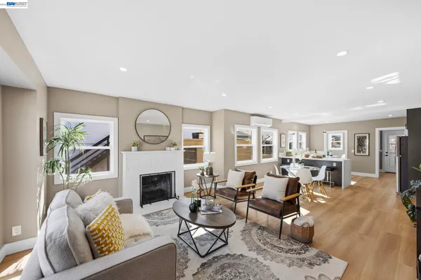 a living room with furniture a fireplace a rug and a large window