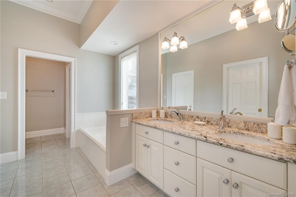 16133 North Point Road Huntersville, NC 28078 - Photo 15 of 42 a spacious bathroom with a granite countertop double vanity sink a mirror and a bathtub