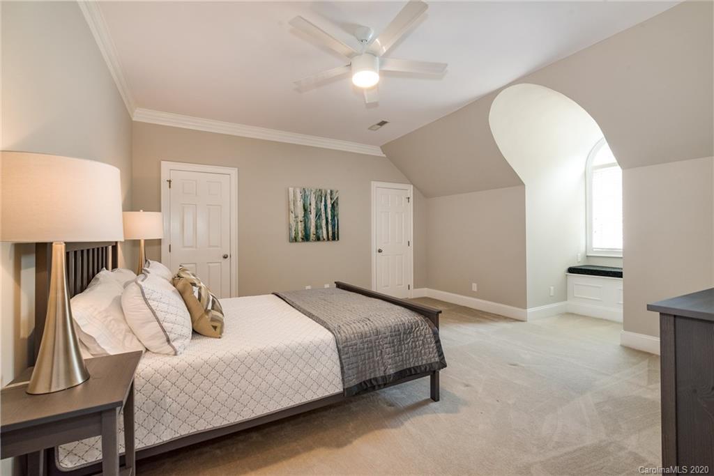 16133 North Point Road Huntersville, NC 28078 - Photo 24 of 42 a bedroom with a large bed and a lamp