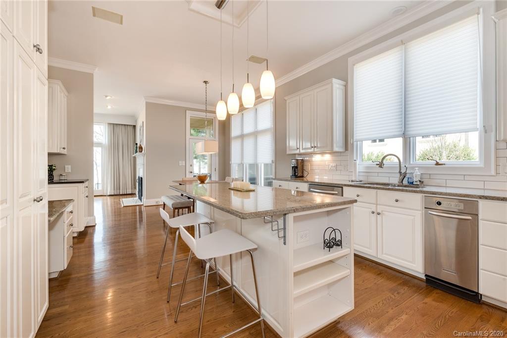 16133 North Point Road Huntersville, NC 28078 - Photo 9 of 42 a large kitchen with kitchen island granite countertop a stove a sink and white cabinets with wooden floor
