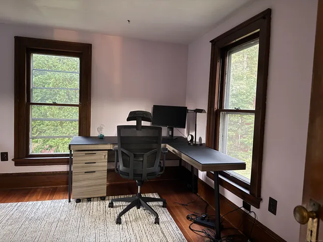 a view of a workspace with furniture and a window