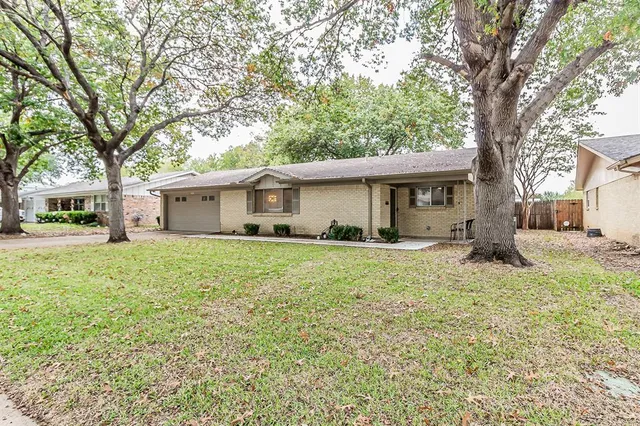 a front view of a house with a yard and trees