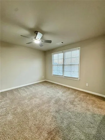 an empty room with windows and ceiling fan view