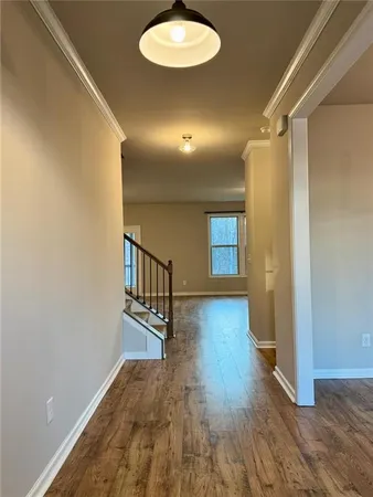 a view of a hallway with wooden floor and a chandelier