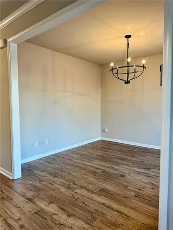 a view of a room with wooden floor and ceiling fan