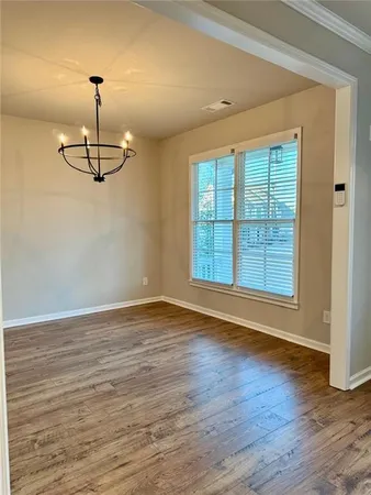 a view of a room with wooden floor ceiling fan and windows