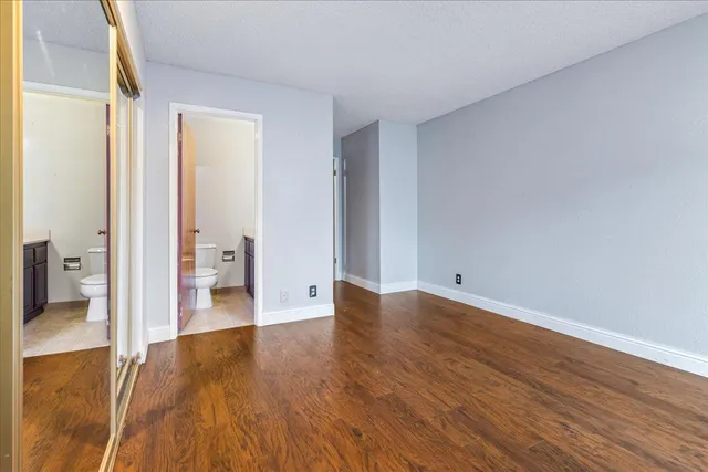 a view of a room with wooden floor and a bathroom