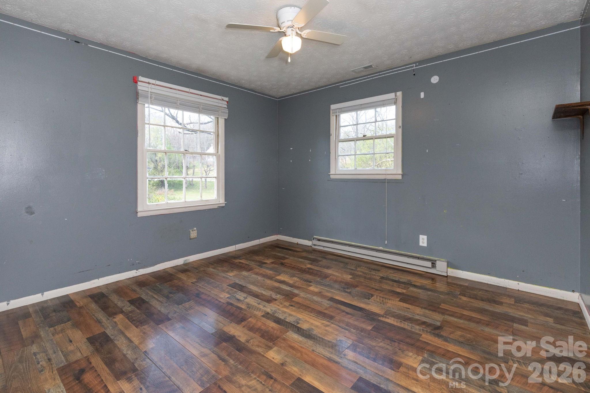 380 Woodland Church Road Clyde, NC 28721 - Photo 12 of 23 a view of an empty room with wooden floor and a window