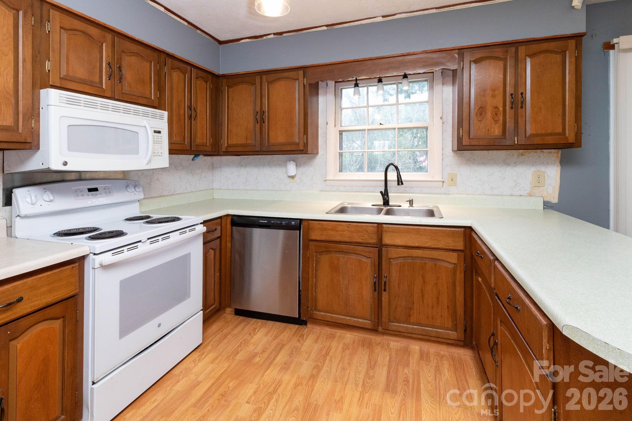 380 Woodland Church Road Clyde, NC 28721 - Photo 3 of 23 a kitchen with stainless steel appliances sink a microwave and cabinets