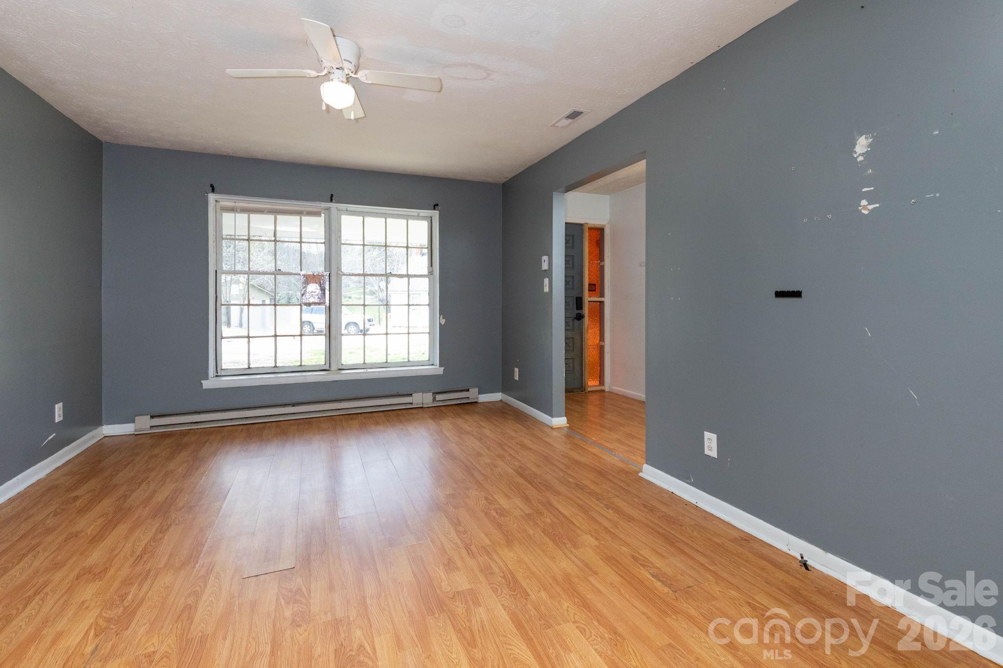380 Woodland Church Road Clyde, NC 28721 - Photo 4 of 23 an empty room with wooden floor and windows