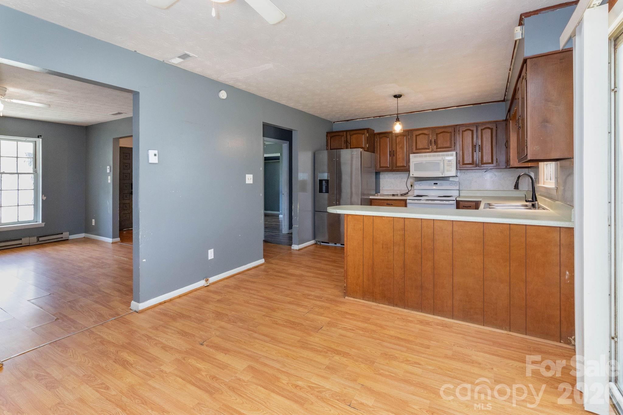 380 Woodland Church Road Clyde, NC 28721 - Photo 6 of 23 a kitchen with stainless steel appliances granite countertop a refrigerator sink and cabinets