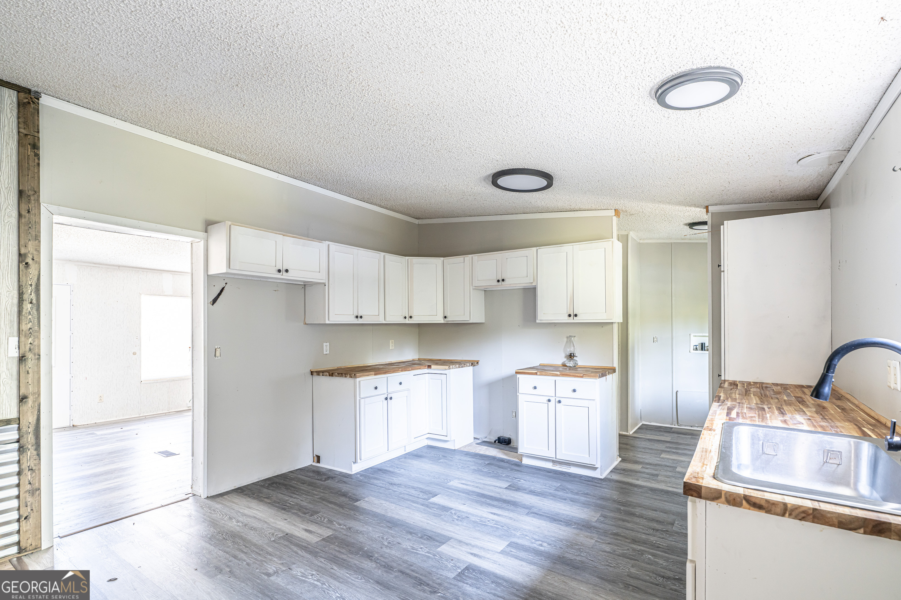 71 Kirk Road Northwest White, GA 30184 - Photo 9 of 43 a kitchen with white cabinets and wooden floor
