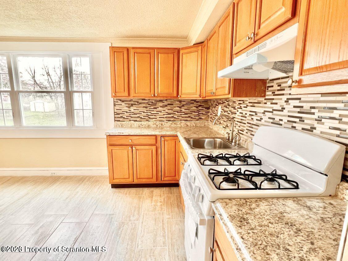 a kitchen with a stove a sink and a microwave