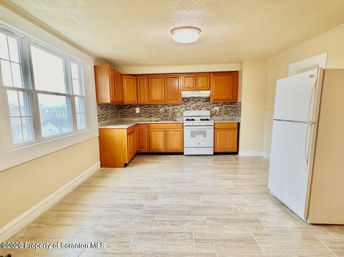 636 Beech Street, Unit 2 Scranton, PA 18505 - Photo 2 of 26 a large kitchen with stainless steel appliances granite countertop a refrigerator a stove and a wooden floors