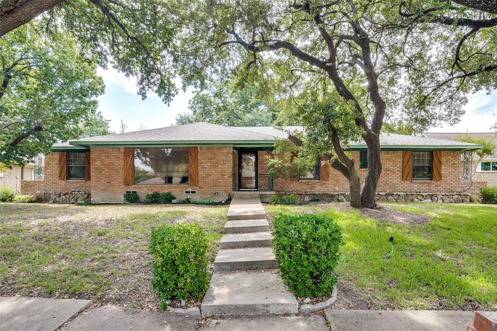 1310 Stony Brook Lane Garland, TX 75043 - Photo 1 of 1 a front view of a house with a garden and trees