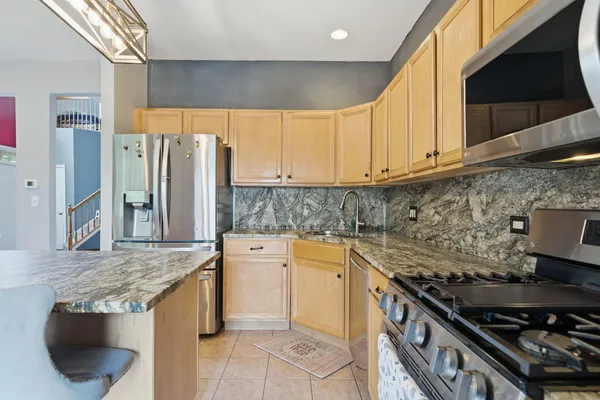 a kitchen with stainless steel appliances granite countertop a stove a sink and a microwave