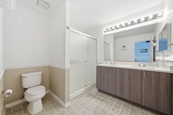 a bathroom with a toilet a sink and mirror