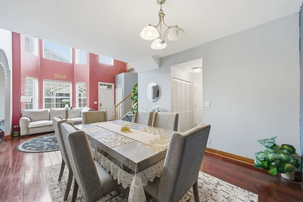 a view of a dining room with furniture a chandelier and wooden floor