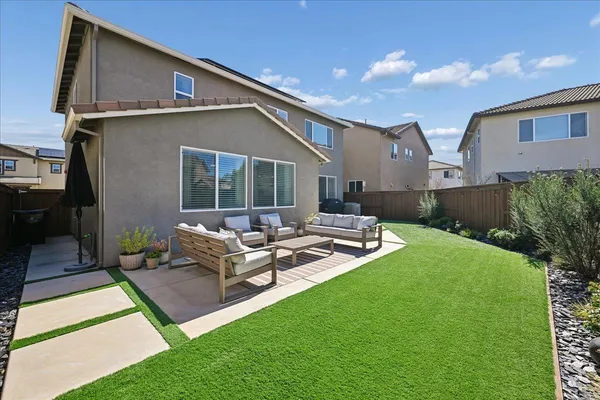 a backyard of a house with table and chairs