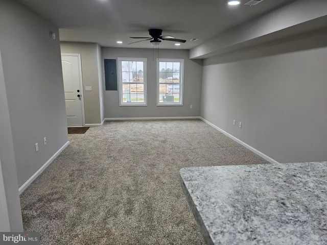 an empty room with windows and cabinet