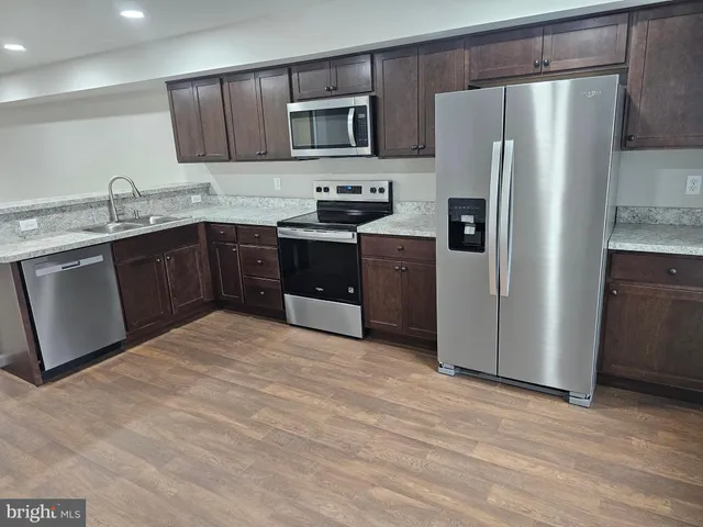 a kitchen with stainless steel appliances granite countertop a refrigerator stove a sink and dishwasher