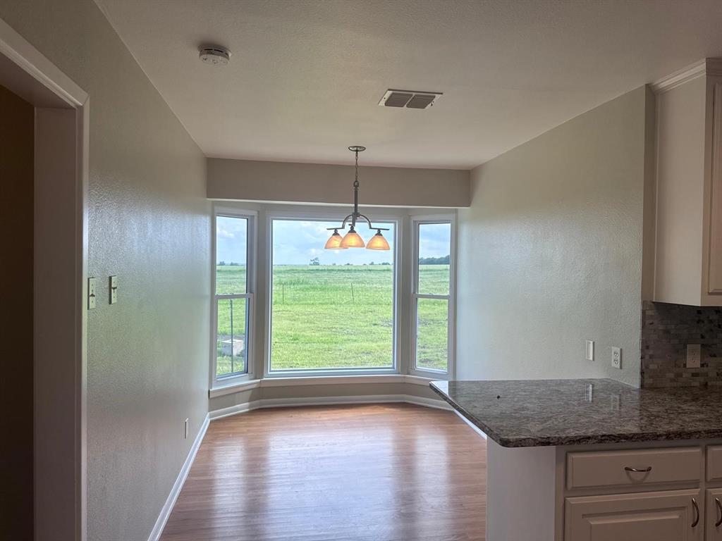 626 Stiff Chapel Road Gunter, TX 75058 - Photo 13 of 40 a kitchen with kitchen island granite countertop a stove a sink and a window