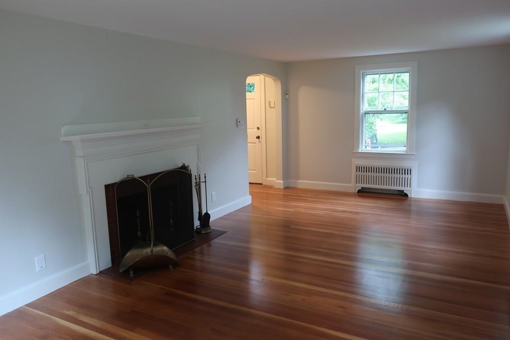 4 Payson Street Lexington, MA 02421 - Photo 11 of 22 an empty room with wooden floor a fireplace and windows