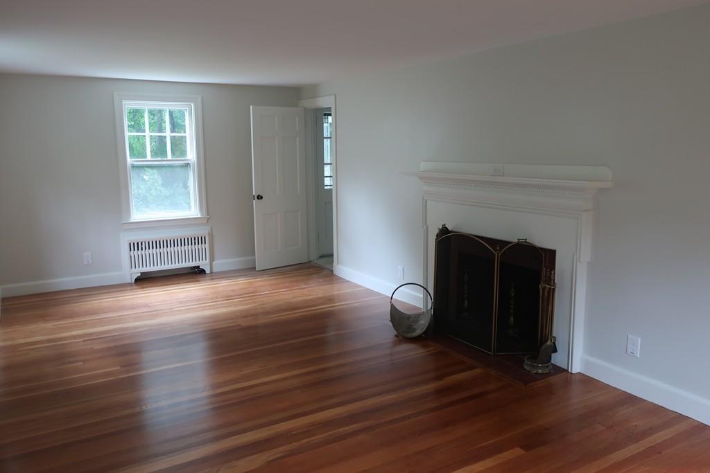 4 Payson Street Lexington, MA 02421 - Photo 10 of 22 an empty room with wooden floor and fireplace