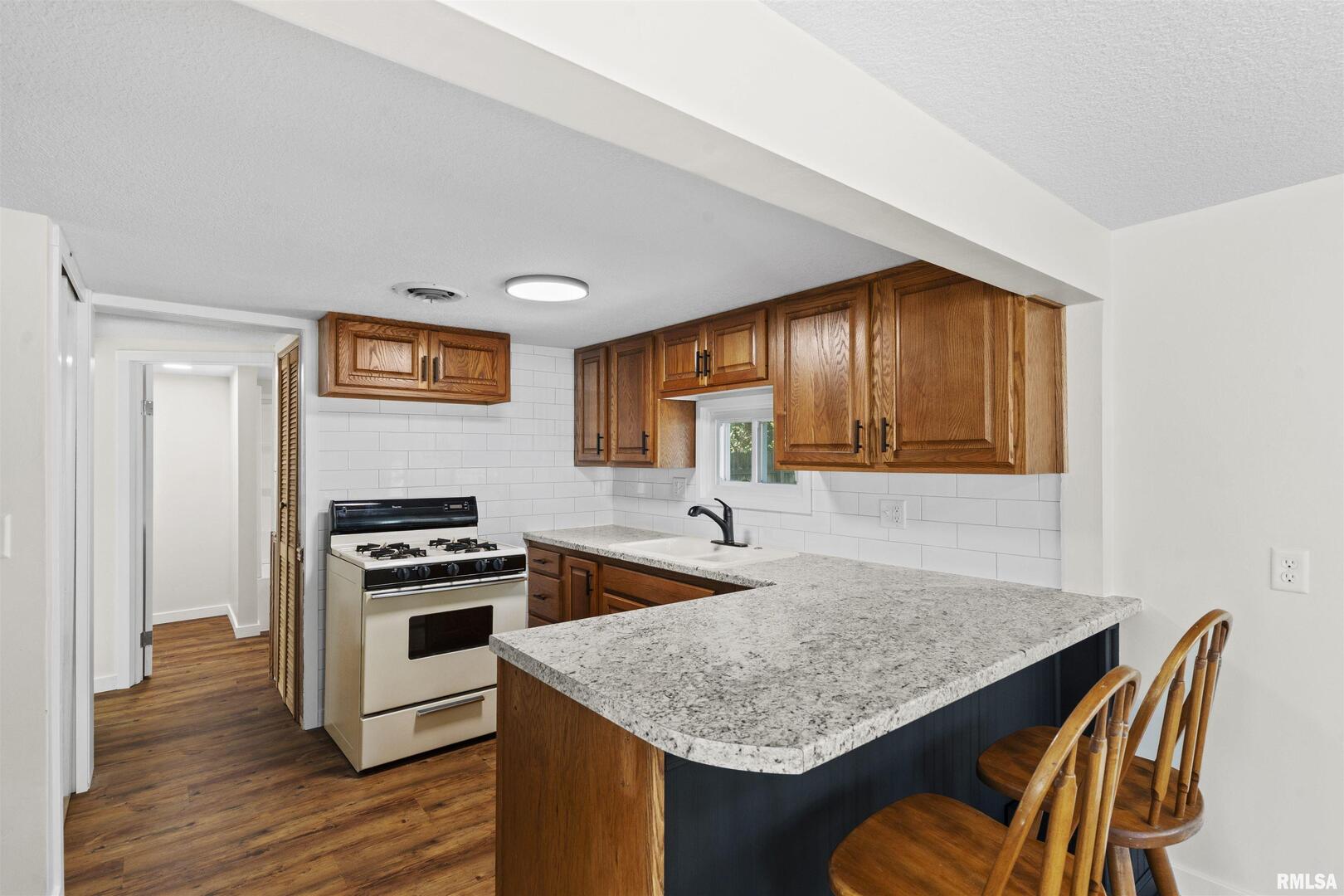 1501 43rd Street Moline, IL 61265 - Photo 8 of 27 a kitchen with stainless steel appliances granite countertop a stove a sink and a refrigerator