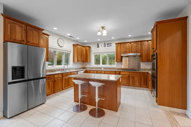 a kitchen with stainless steel appliances granite countertop a refrigerator and a sink